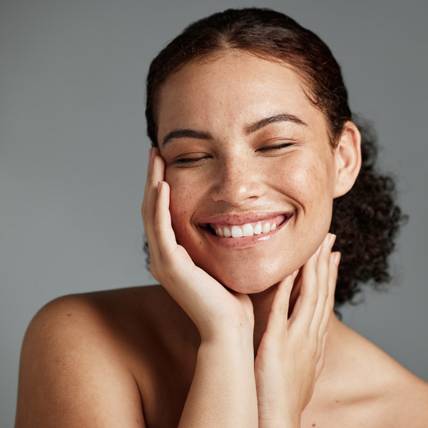 woman holding her face and smiling